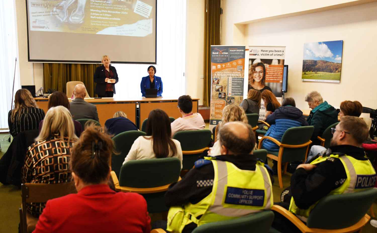 People sitting in room looking at screen