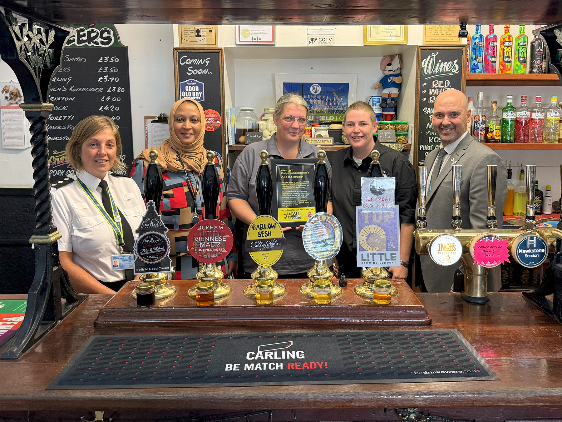 Group of people behind bar in a pub