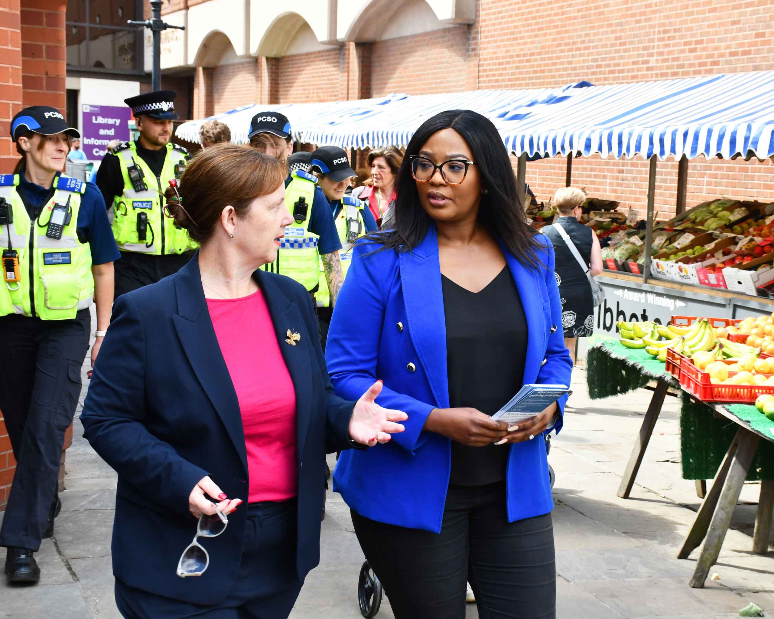 3078-DSC_9647 a Commissioner walking through an outside market with police officers