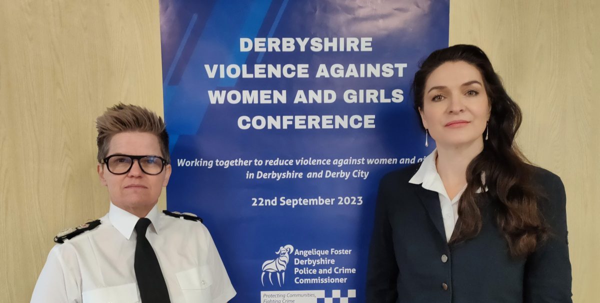 Chief Constable and Commissioner in front of Conference Banner