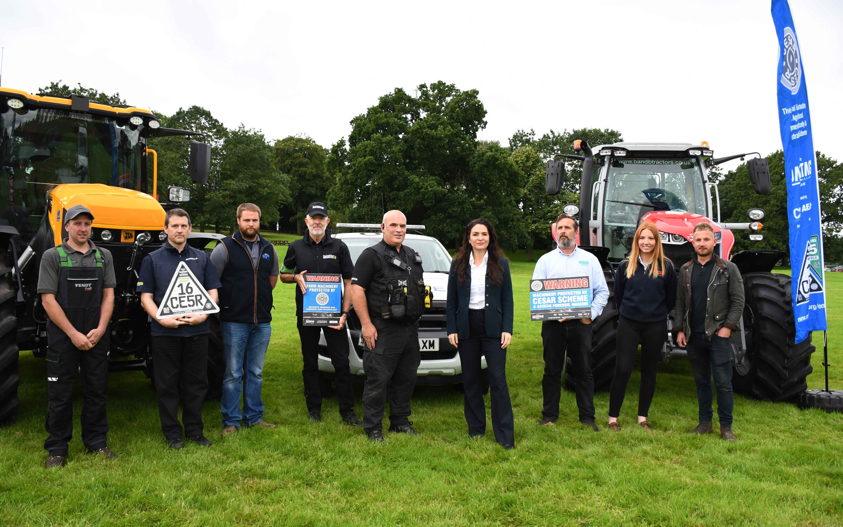 Police and Crime Commissioner with rural crime team in front of tractors in a field